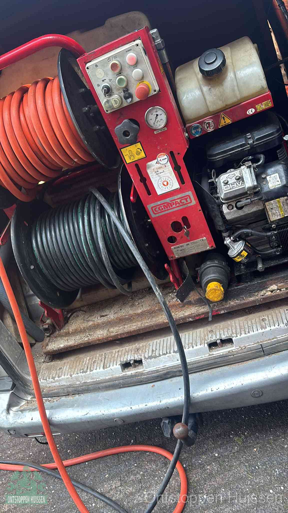 Een rood hogedruk-rioolreinigingstoestel in de laadbak van de bedrijfsbus, apparatuur voor een hardnekkige afvoerverstopping in Huissen
