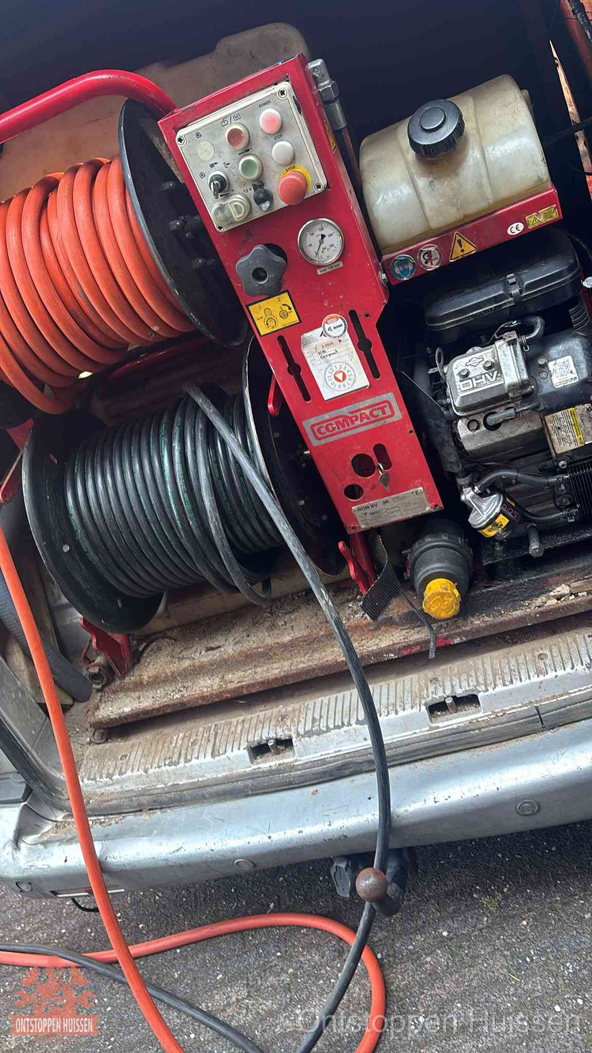 Een rood hogedruk-rioolreinigingstoestel met slangen in de laadbak van de bedrijfsbus, apparatuur voor een hardnekkige wc-verstopping in Huissen