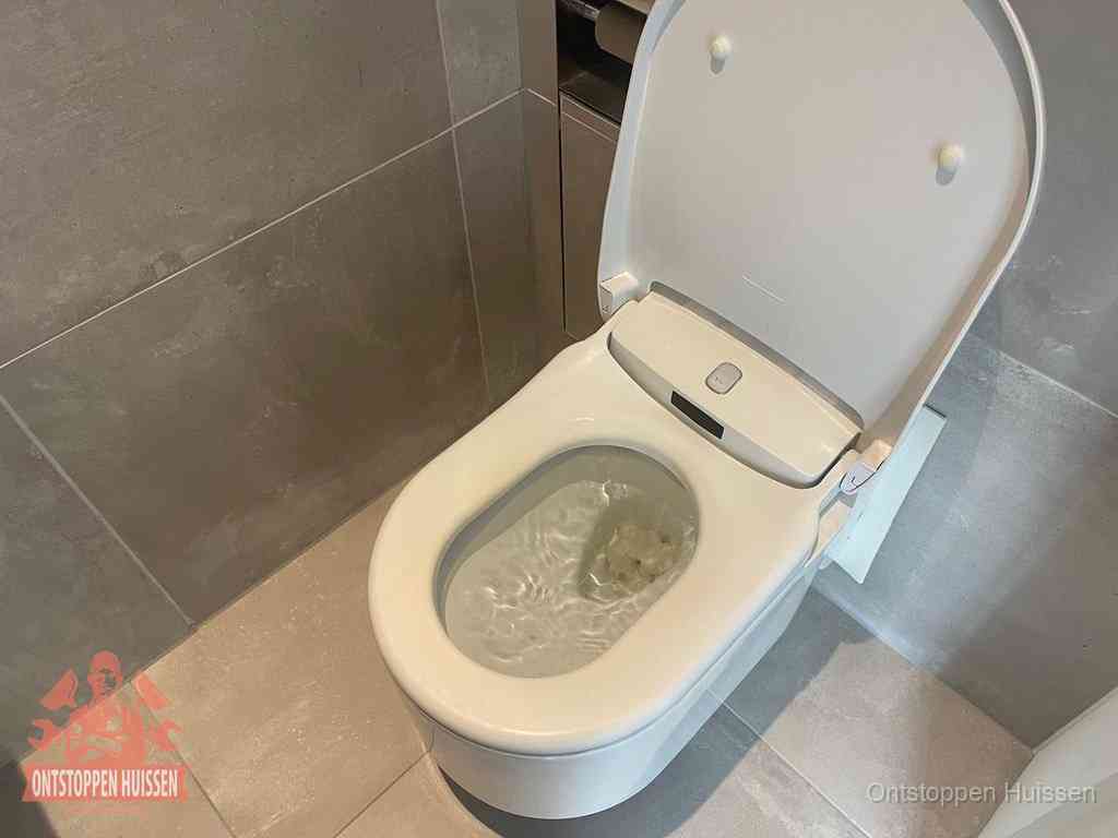 Een toiletpot vol troebel water met drijvend papier en restanten, de meest voorkomende oorzaak van een verstopte wc in Huissen