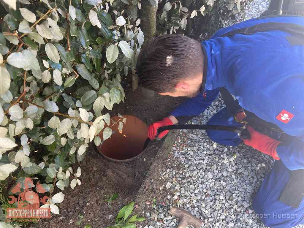 Monteur reinigt een rioolput met een slang, periodieke rioolreiniging in Huissen