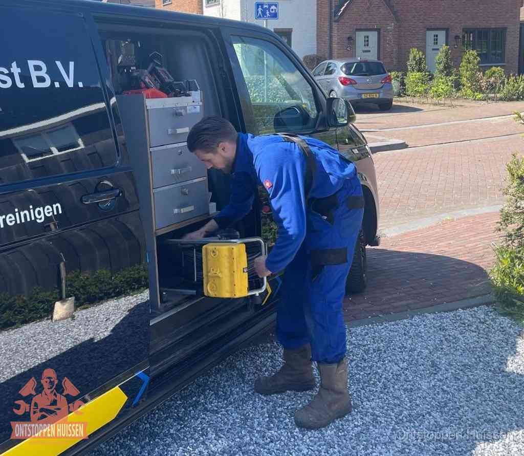 Een monteur pakt apparatuur uit de bedrijfsbus voor service aan huis, het moment om een professional in te schakelen in Huissen