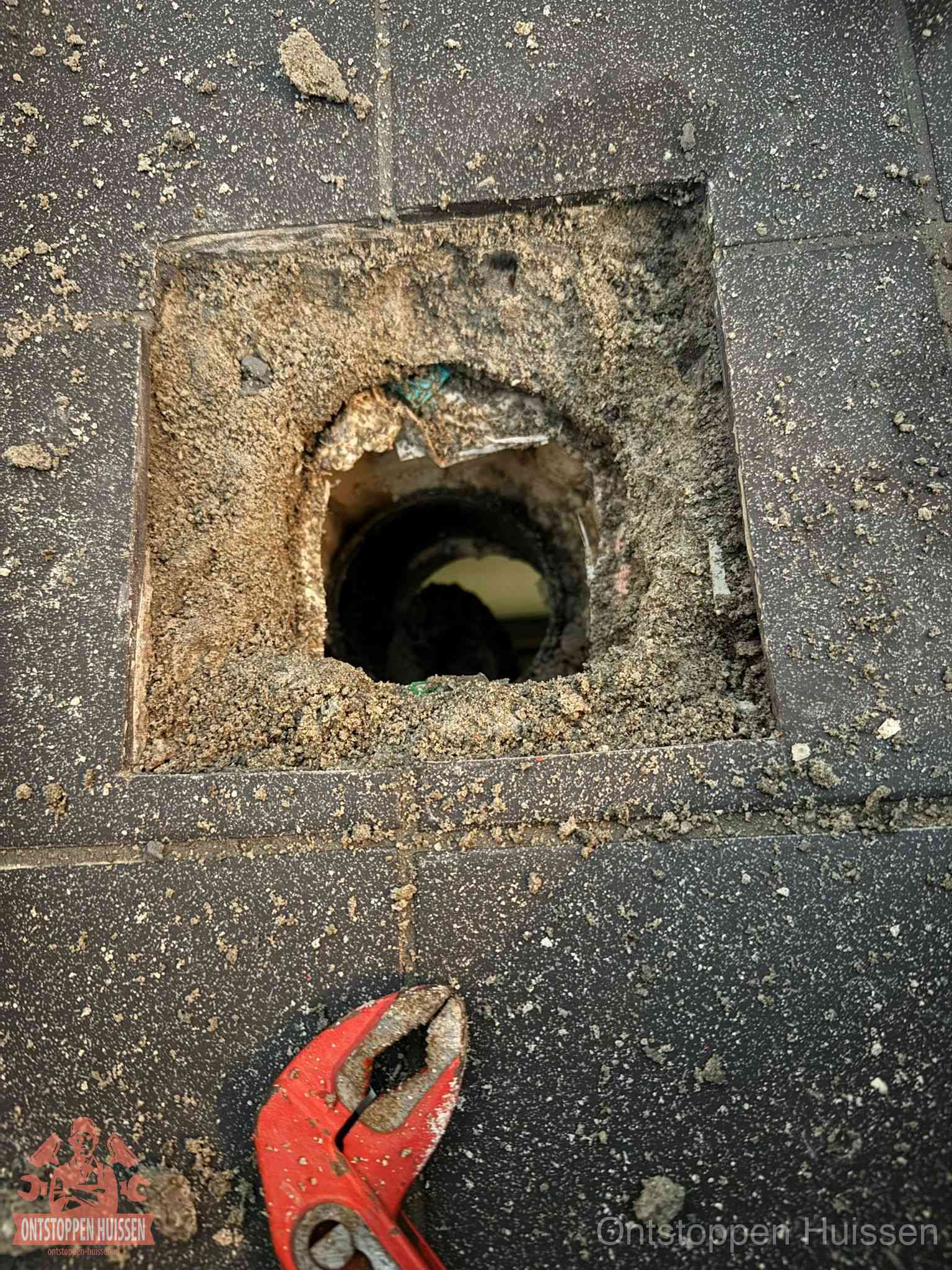 Geopend rioolputje op de erfgrens dat laat zien wie eigenaar is van de riolering in Huissen
