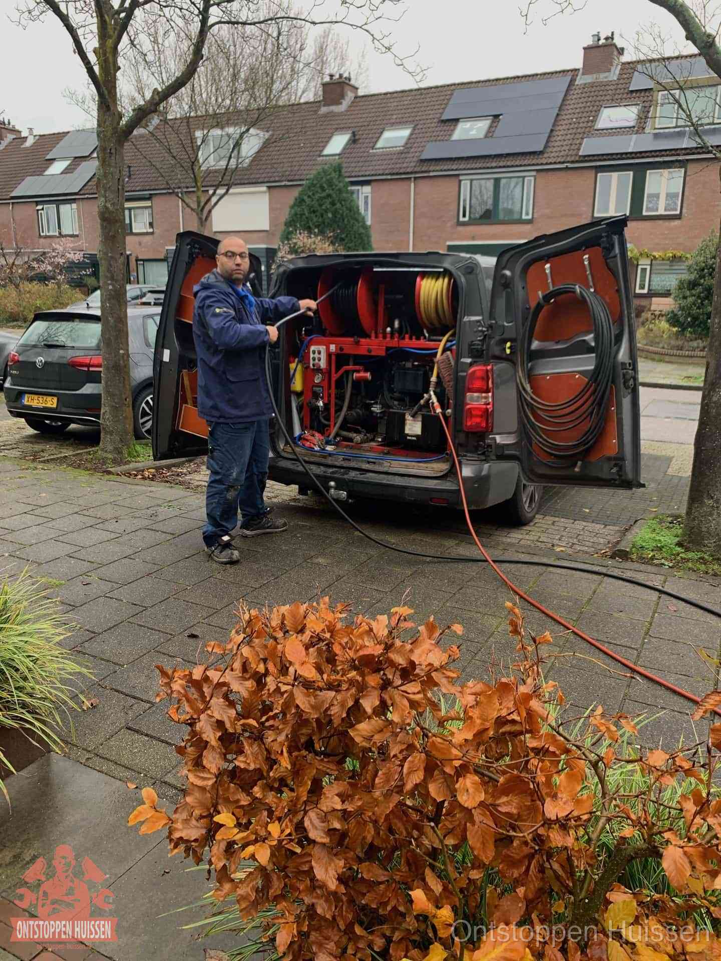 Monteur met rioolreinigingsbus levert rioolservice in de wijk in Huissen