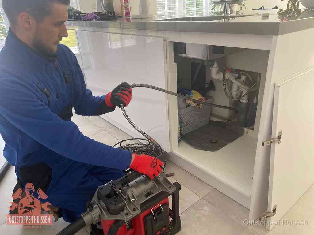 Een monteur reinigt de keukenafvoer grondig met een veermachine om terugkerende gootsteenverstoppingen te voorkomen in Huissen